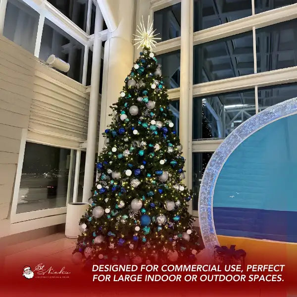 Decorated Christmas tree with teal blue silver and white ornaments in a large indoor space.