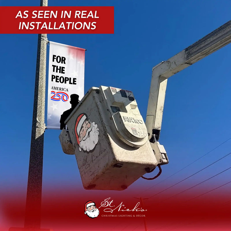 America 250 salute For The People street banner installed on city light pole using bucket truck during installation