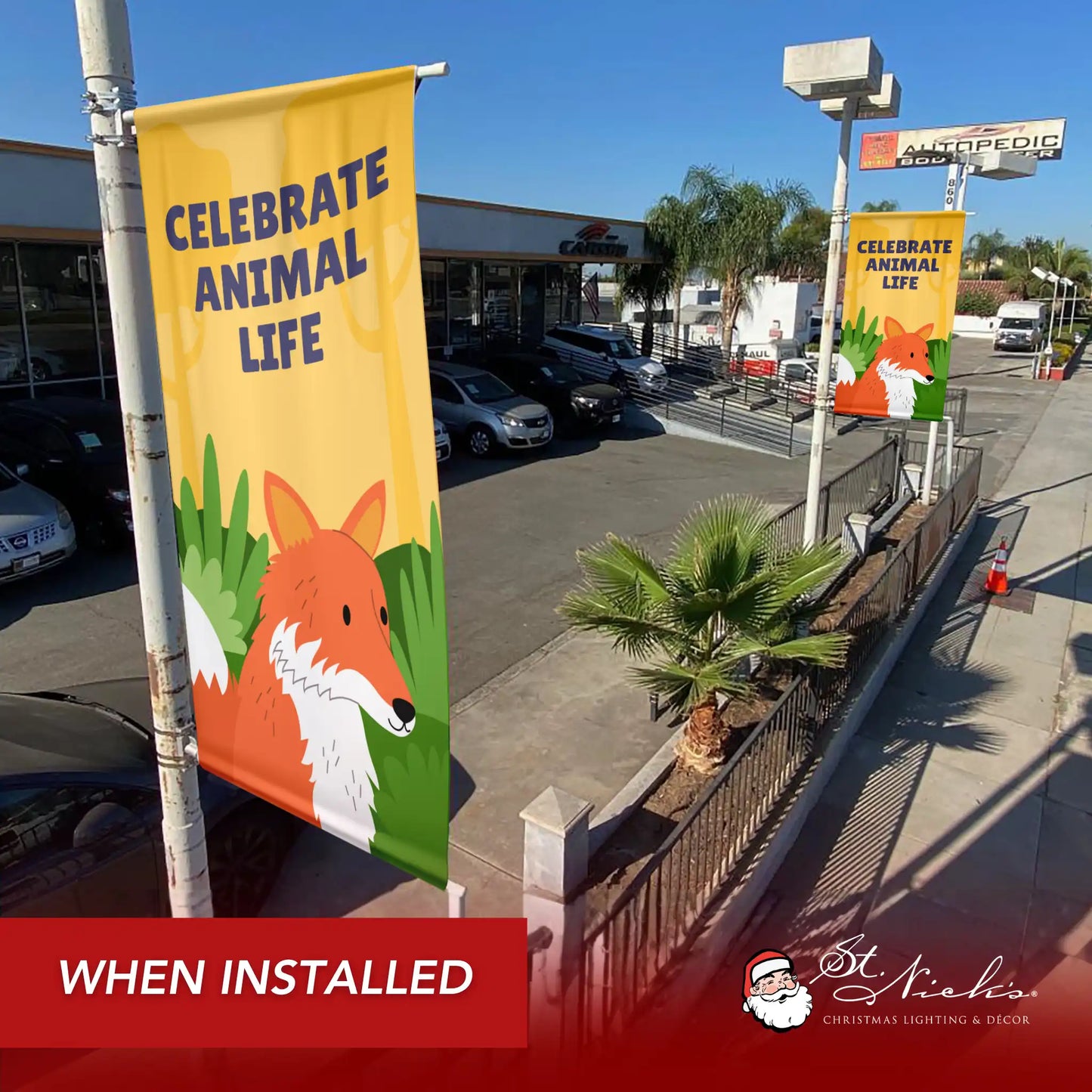 Celebrate Animal Life yellow street banner displayed along commercial sidewalk