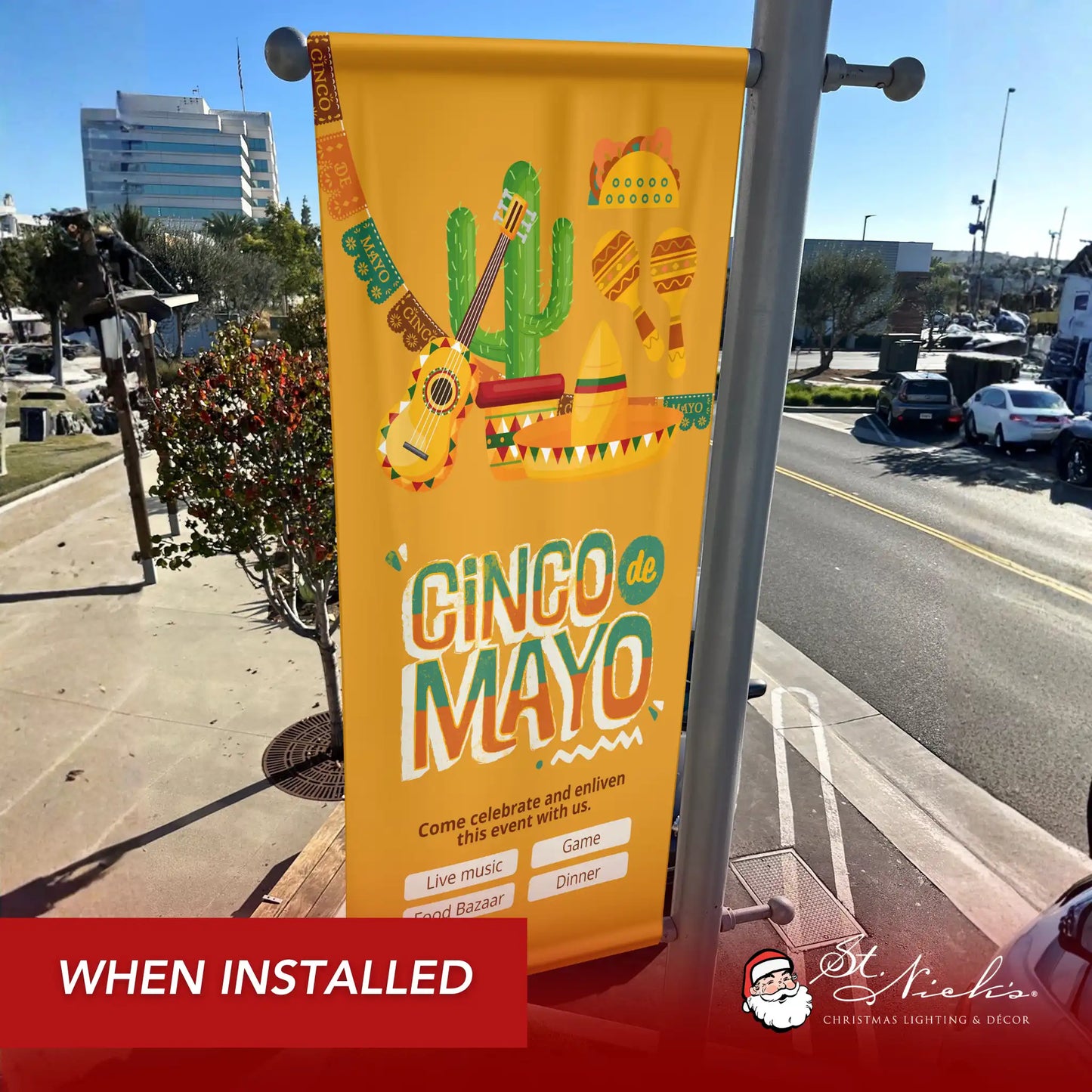 Cinco de Mayo illustrated pole banner with guitar and sombrero design shown installed on city street pole