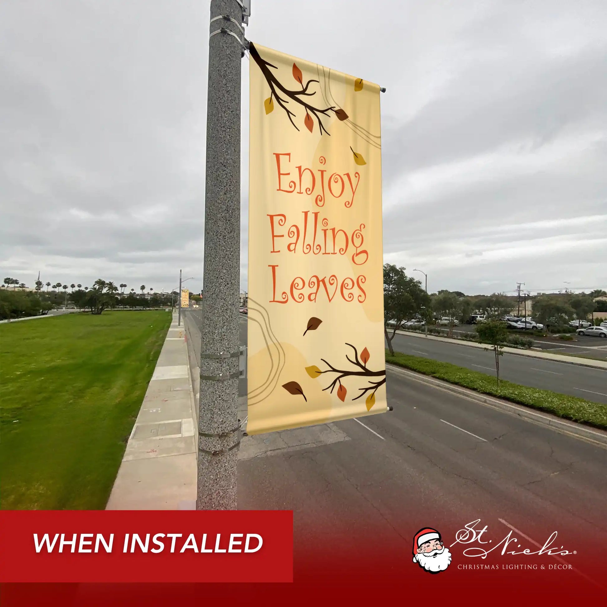 Enjoy Falling Leaves fall pole banner installed along city street for seasonal autumn décor