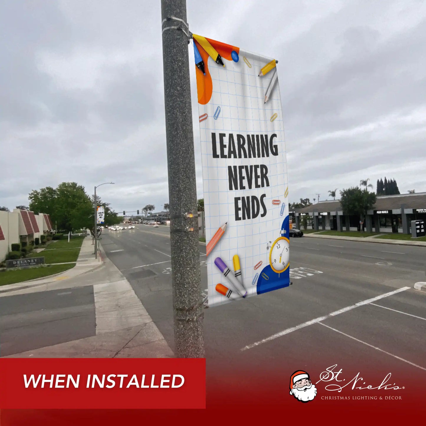 Learning Never Ends school pole banner installed along city street for back-to-school décor