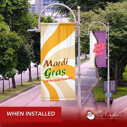 Mardi Gras “Let the Good Times Roll” pole banner displayed on decorative street pole along landscaped roadway