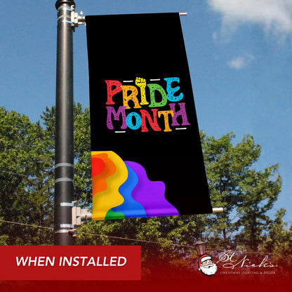 Black Pride Month pole banner with rainbow wave design shown installed on downtown street pole