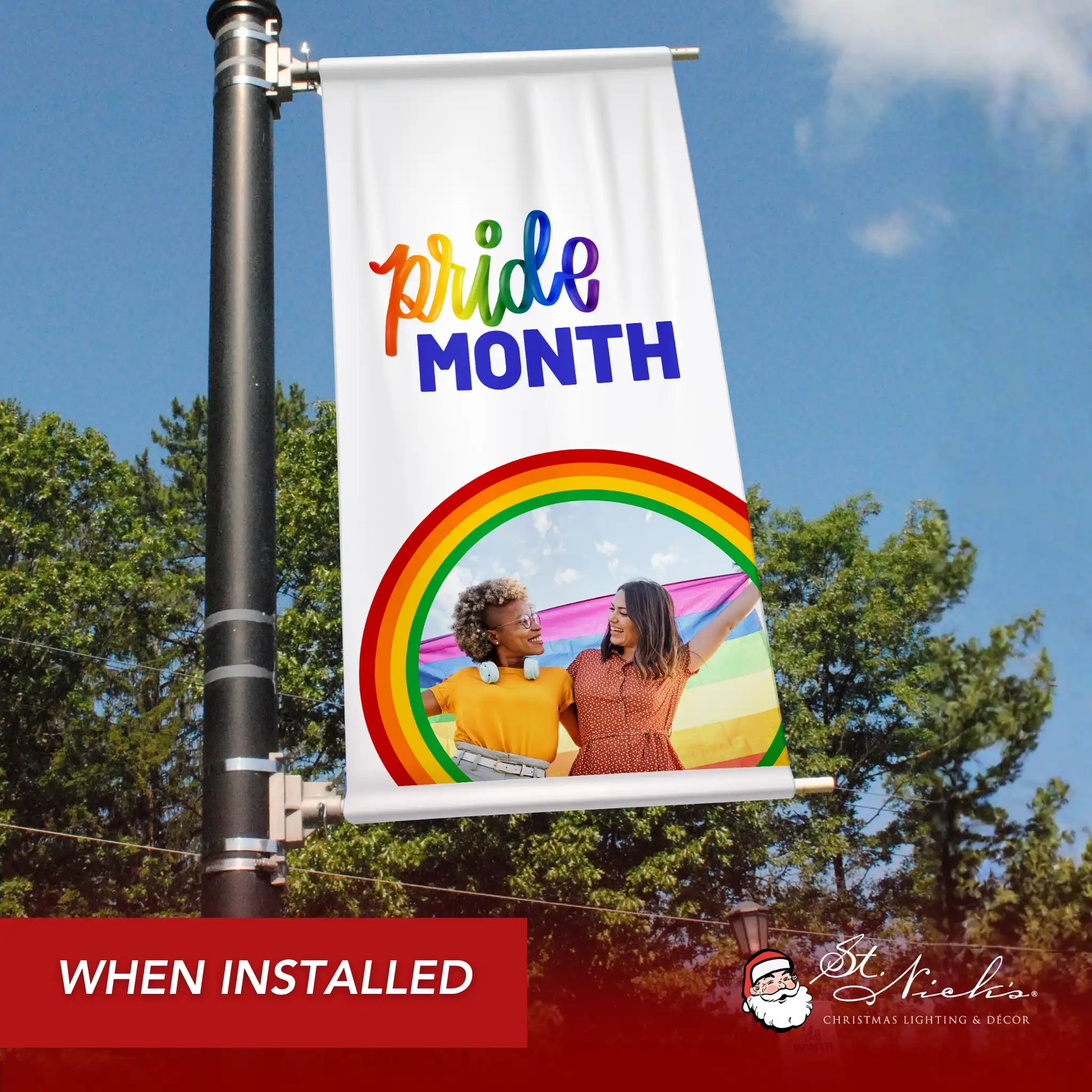 Pride Month photo pole banner shown installed on city street pole with rainbow graphic and inclusive message