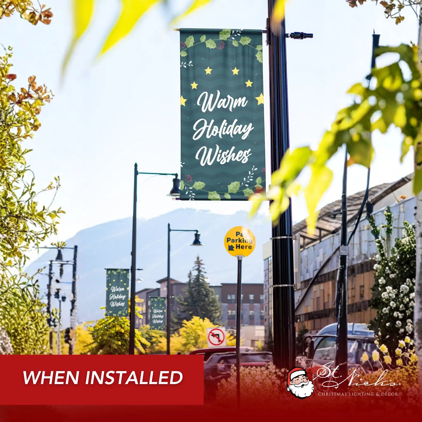 Warm Holiday Wishes Christmas pole banner installed along city street for seasonal holiday décor
