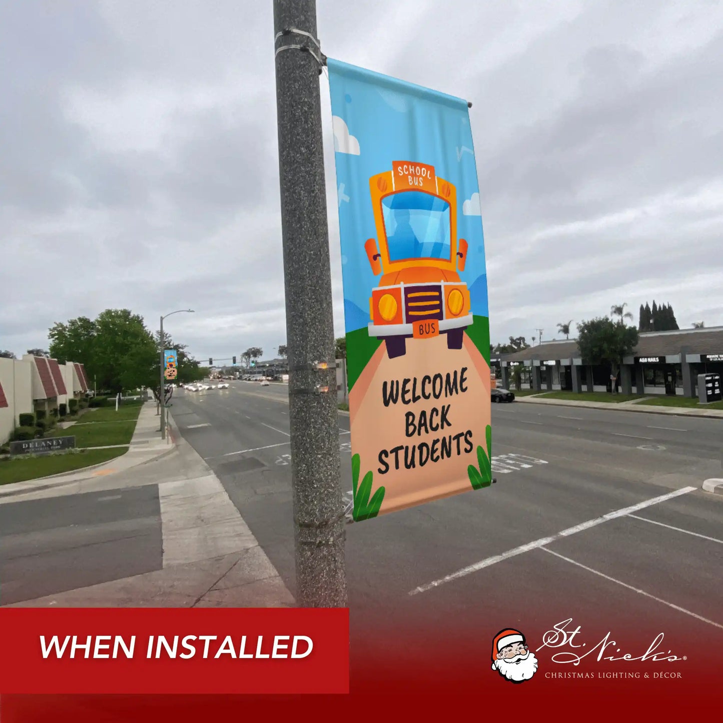 Welcome Back Students school bus pole banner installed along city street for back-to-school décor