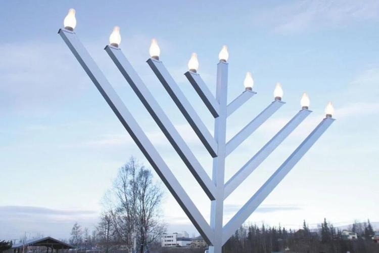 Large outdoor menorah with lit candles 