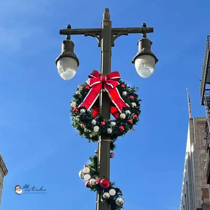 Decorative wreath with a red bow on a streetlight 