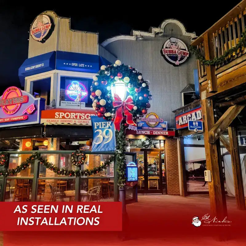 Decorative Christmas wreath with lights and ribbons in front of a building 